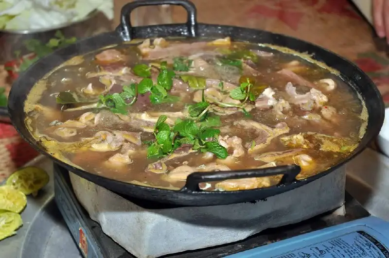 Traditional thắng cố simmering in large pan Thắng cố - traditional horse stew - best food sapa