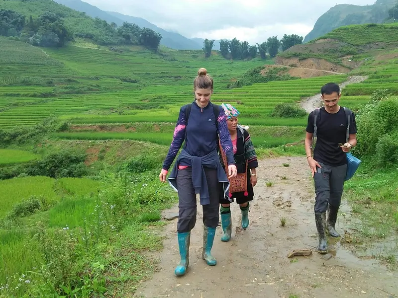 Travelers and locals walking muddy Sapa path can you trek sapa without a guide